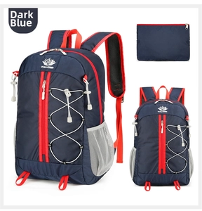 Detail of dark blue outdoor backpack showing red zippers and matching storage pouch