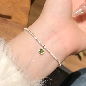 Élégant bracelet en chaîne argentée avec un pendentif hexagone en pierre verte au poignet