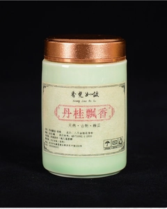 Close-up of Dan-Gui Osmanthus incense powder in a green ceramic jar with bronze metal lid