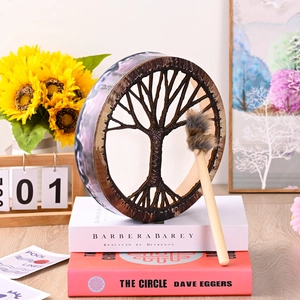 Detail of Tree of Life Shaman Drum with wooden frame and mallet on books