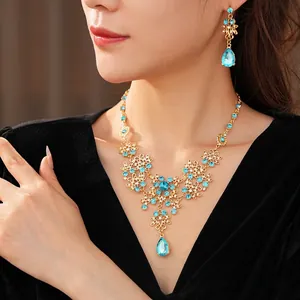 Vintage gold necklace and earrings set with light blue crystals on floral motifs