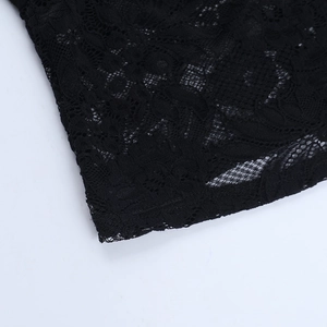 Close-up of black floral lace fabric texture and mesh detail on a sexy hollow-out T-shirt