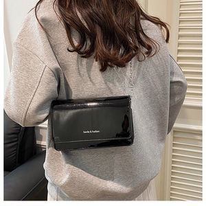 Glossy black patent leather flap shoulder bag with chain strap and brand logo