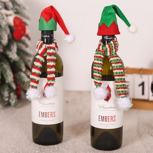 Close-up of Christmas wine bottle decoration set with knitted elf hat and striped scarf