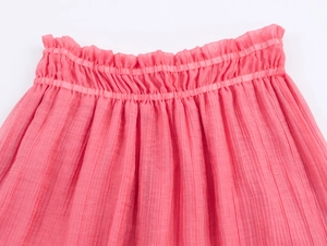Detail of pink bohemian skirt with elastic waist, ruffle trim and pleated texture