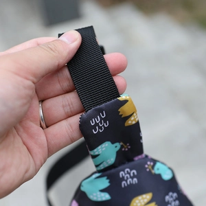 Detail of sturdy nylon strap and bird print fabric on kids cartoon crossbody bag