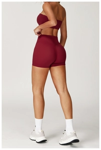 Detailed side view of high-waisted burgundy yoga shorts and sports bra set for women