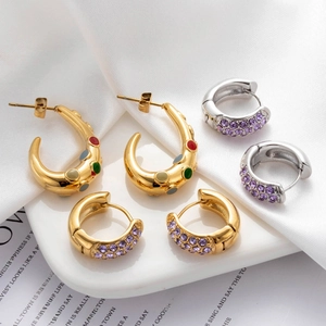 Titanium steel C-shaped earrings with colorful crystals on elegant white silk fabric