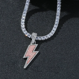 Detail shot of iced-out lightning bolt pendant with pink gems on a silver tennis chain