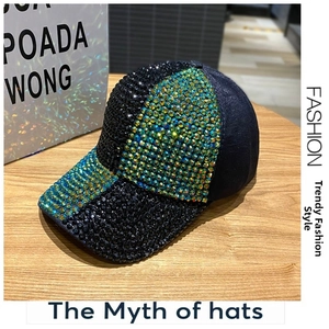 Detailed close-up showing hand-set blue and green rhinestones on black baseball cap brim