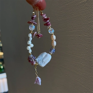 Detailed close-up of Baroque freshwater pearl bracelet with rose quartz and gold accents