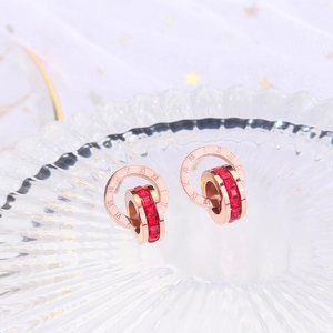 Rose gold Roman numeral earrings with interlocking rings and red cubic zirconia stones
