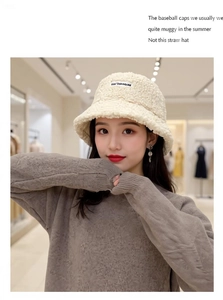 Close-up of cream white faux lamb wool bucket hat with embroidered brand logo
