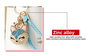 Detail of rhinestone fox keychain with light blue crystals, pearls and gold hardware