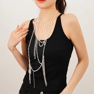 Elegant layered glass pearl body chain with golden accents on a black top