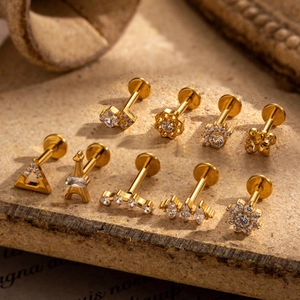 Set of 9 gold G23 titanium labret studs with zircon inlays featuring geometric shapes