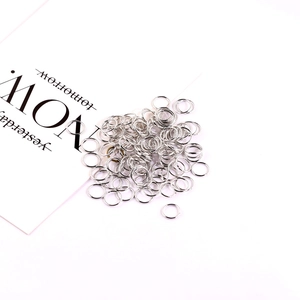 Silver round metal jump rings for DIY jewelry making on white background with decorative card