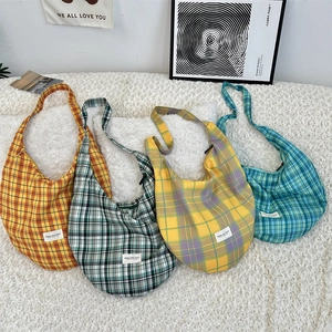 Detailed arrangement of four retro plaid canvas hobo bags in various vibrant color schemes