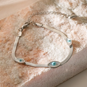 Silver snake chain bracelet featuring three blue evil eye charms and a heart pendant