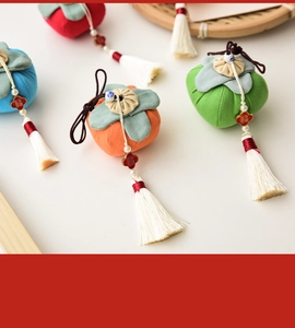 Macro view of handmade fabric persimmon pendants with tassels and fortune charms