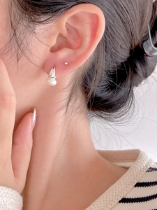 Detailed close-up of a 925 sterling silver pearl earring on a model's ear
