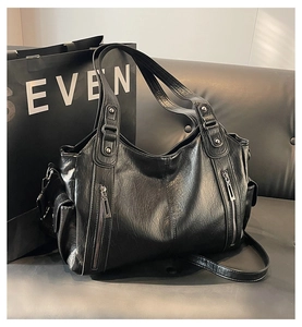 Detailed close-up of retro black PU leather tote with metal zippers and studs texture