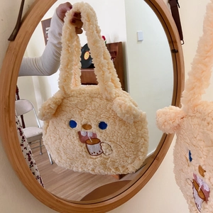 Close-up of beige fleece tote bag featuring cute cartoon embroidery and soft lambskin texture