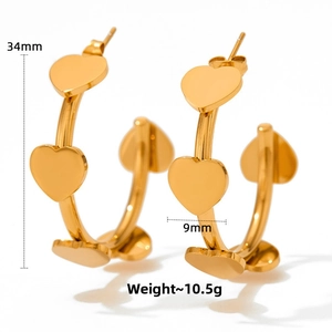 Detail view of gold heart earrings with dimensions 34mm height and 9mm width marked