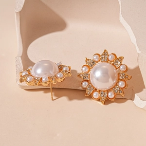 Detailed macro of vintage sunflower earrings with large center pearl and crystal petals