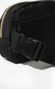 Detail of high-density black nylon fanny pack featuring gold zippers and durable plastic buckles