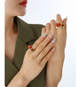 Close-up of gold plated ring with red agate and tiger eye stones worn by a model