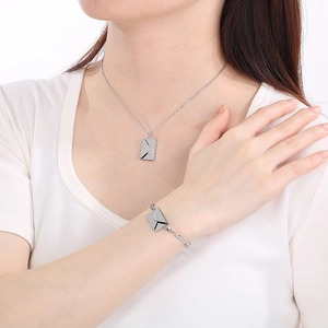 Dettaglio del set collana e bracciale a busta d'argento indossato da una modella reale