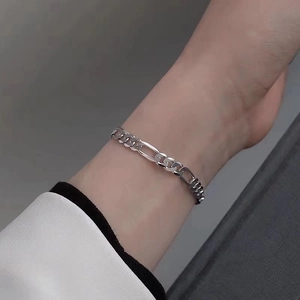 Close-up of silver titanium steel double-layer Figaro bracelet worn on a male wrist
