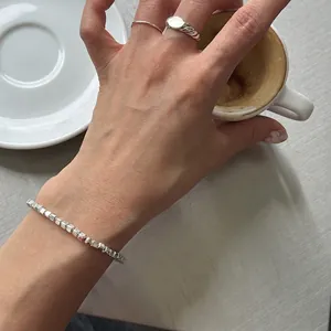 Minimalist S925 sterling silver beaded bracelet and ring set worn in a lifestyle setting