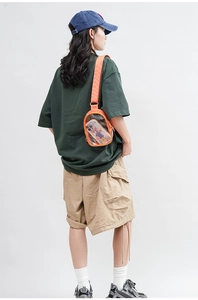 Detail of transparent orange PVC crossbody bag showing internal space and strap texture