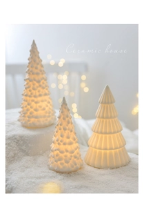 Macro view showing textured ceramic Christmas tree decor with warm glowing LED light effect