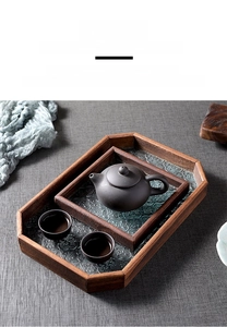 Detail of octagonal wooden tea tray with Begonia pattern embossed glass and teaware