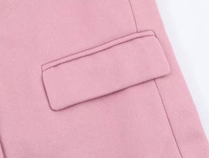 Detail shot of the flap pocket and wool blend fabric on this pink oversized blazer