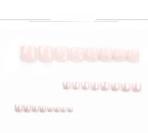 Detail view of pink glitter press-on toenails featuring 3D bow accents and clear texture