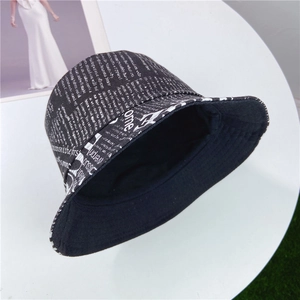 Détail du chapeau cloche en coton et lin avec imprimé journal blanc sur toile noire