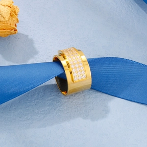 Close-up of a wide 18k gold plated ring with CNC set stones on a blue silk ribbon