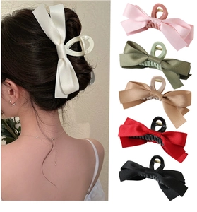 Detail of large satin bow hair claw clips in various colors for French bun styling