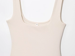 Detail of beige ribbed knit strap and neckline on an elegant sleeveless summer dress