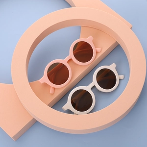 Set of round candy-colored children's sunglasses in matte pink and off-white frames