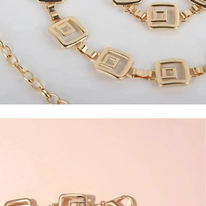 Detail of gold metal waist chain featuring square geometric links and lobster clasp