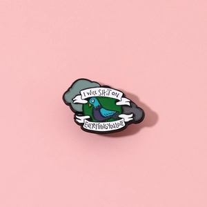 Detail of pigeon enamel pin with funny quote I Will Shit On Everything You Love
