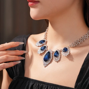 Close-up of a French vintage necklace with blue water-drop crystals on a model neck
