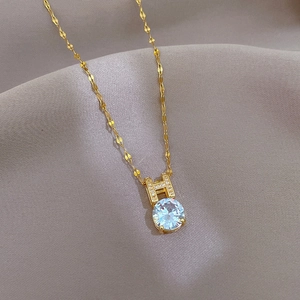 Close-up of a gold titanium necklace featuring a large sparkling cubic zirconia pendant