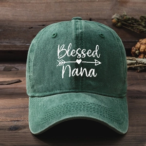 Close-up of Blessed Nana embroidery and heart pattern on washed green cotton baseball cap
