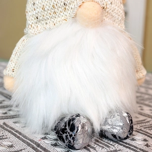 Detailed view of Christmas gnome showing sequins, knit hat and white faux fur beard